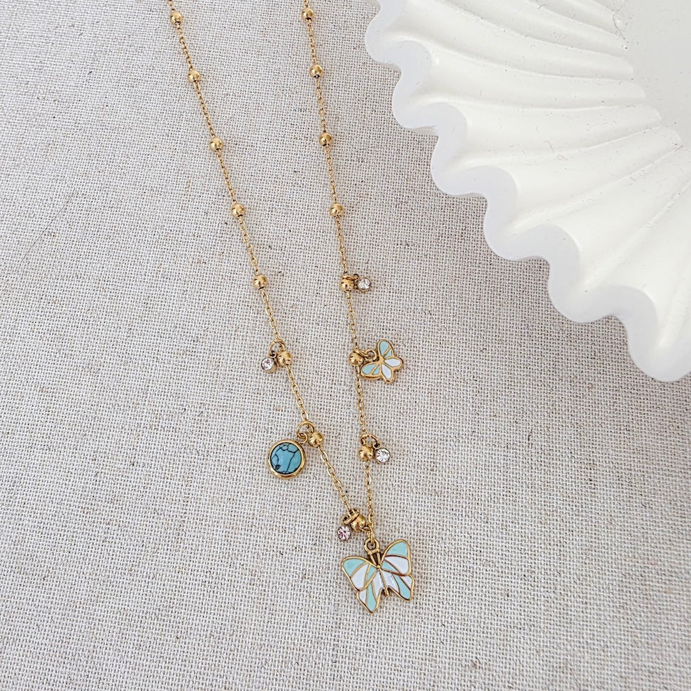Gold butterfly pendant necklace with blue turquoise round stones and small charm beads