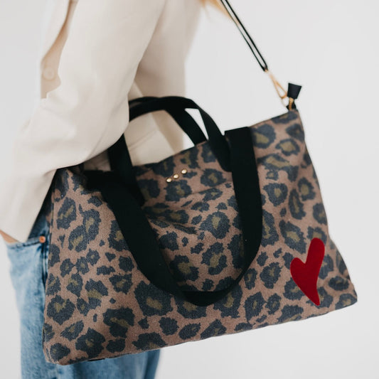 Leopard-print canvas tote with black handles and red heart charm
