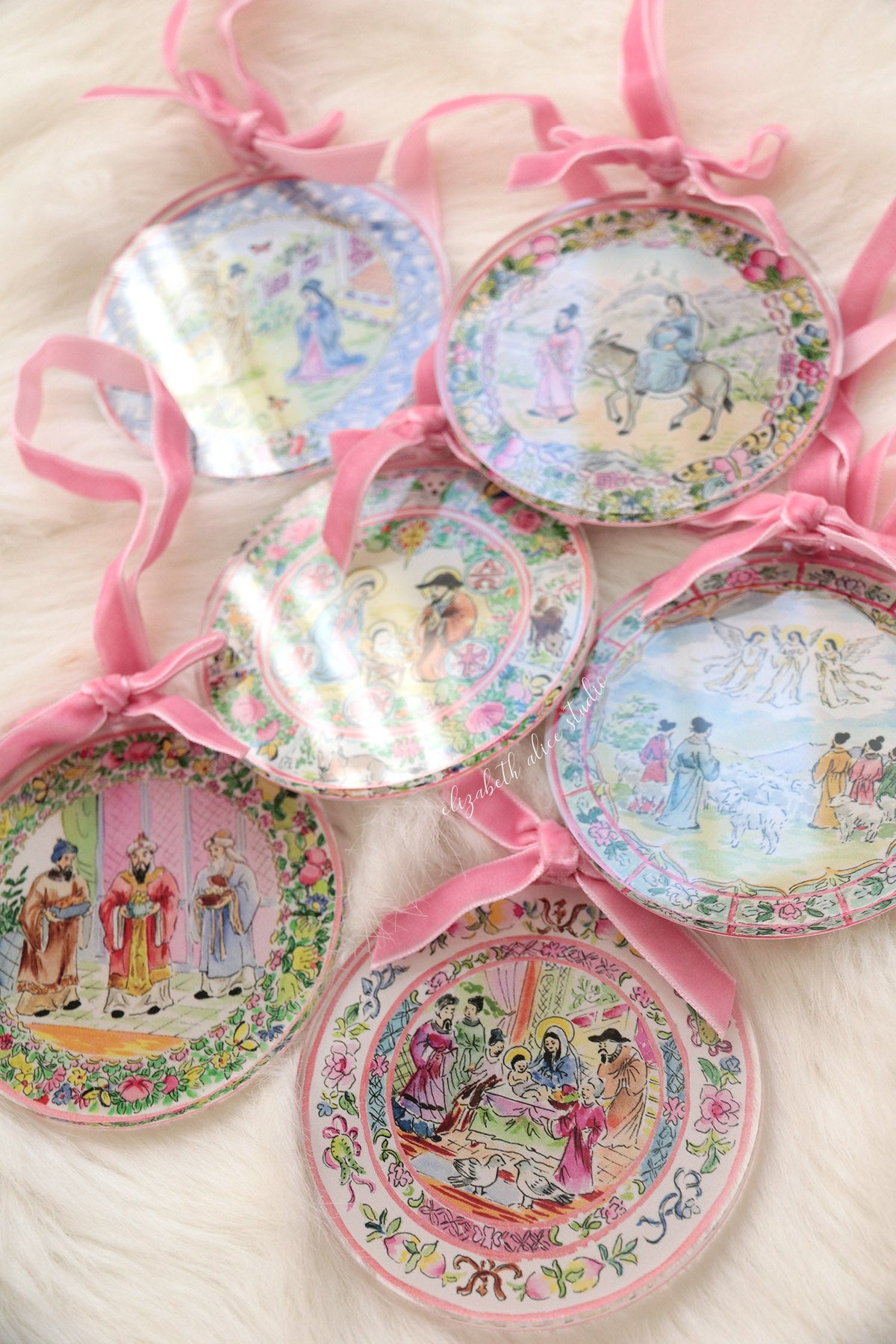 Magi ornament among a group of colorful round ornaments with pink bows