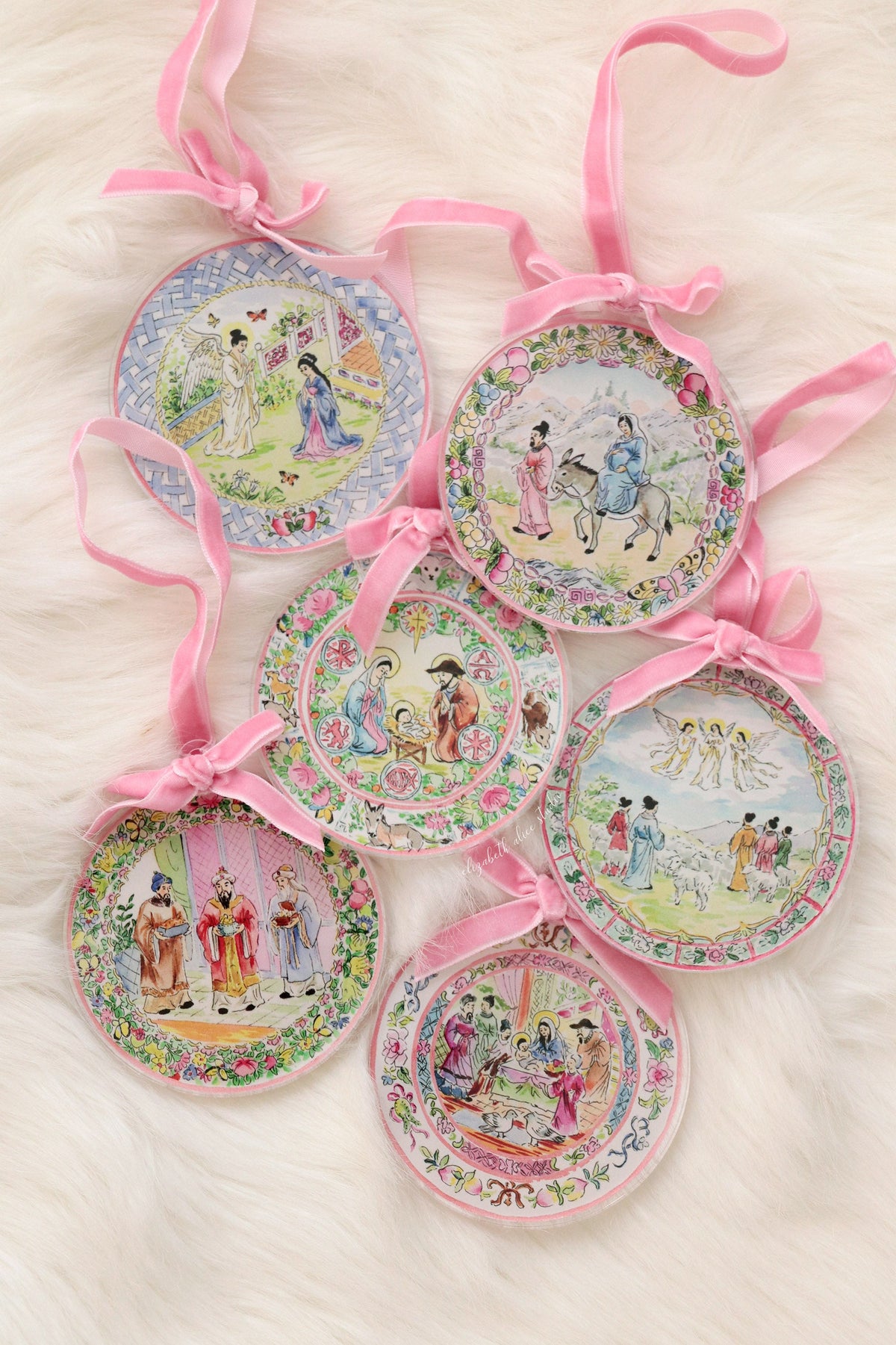 Magi ornament in a group of five round ornaments with pink ribbon hangers