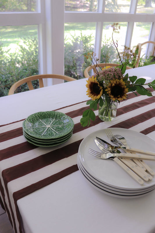 Chocolate stripe table runner with wide cocoa and white stripes on a dining table.