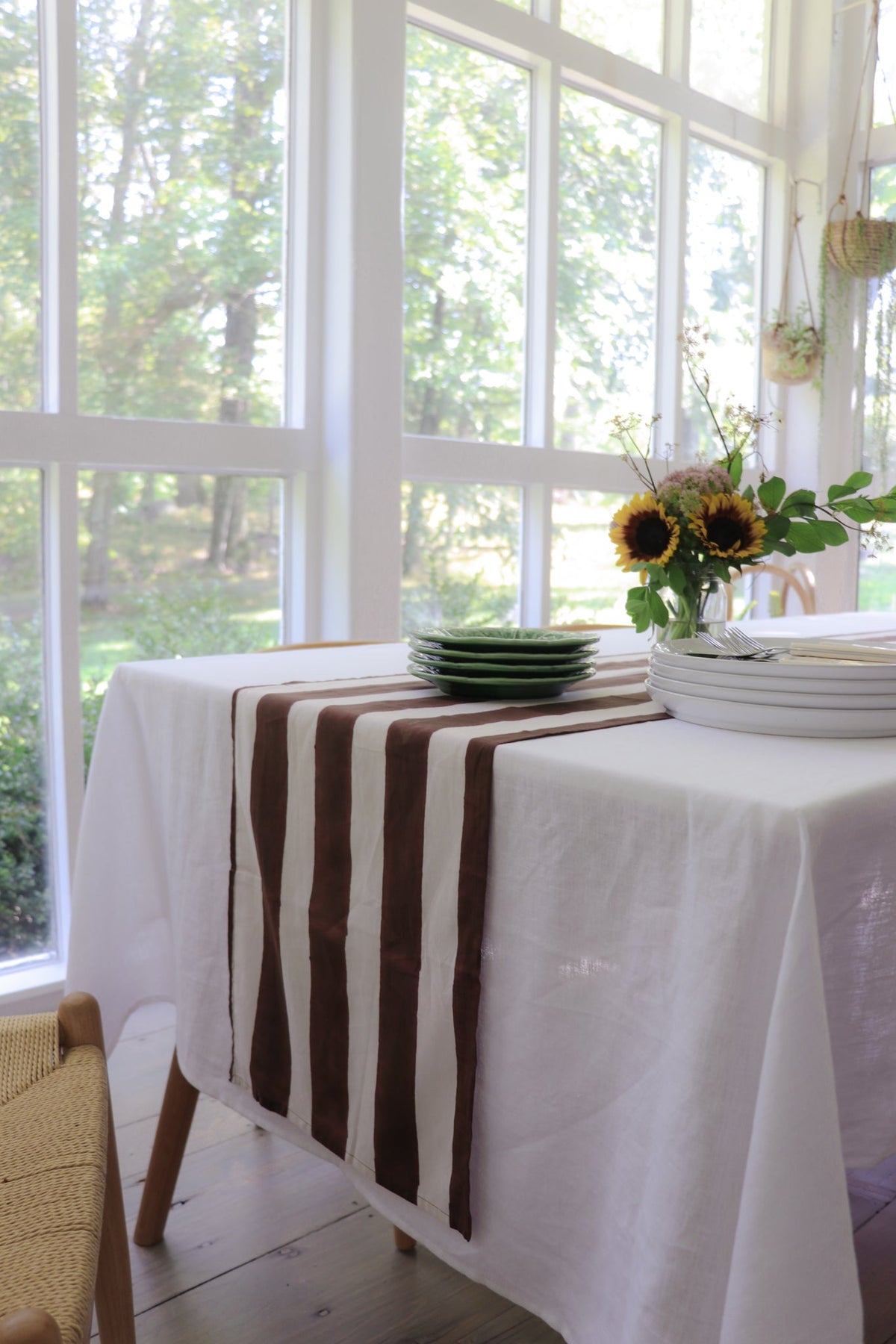 Cocoa and white striped table runner draped over the end of a table.