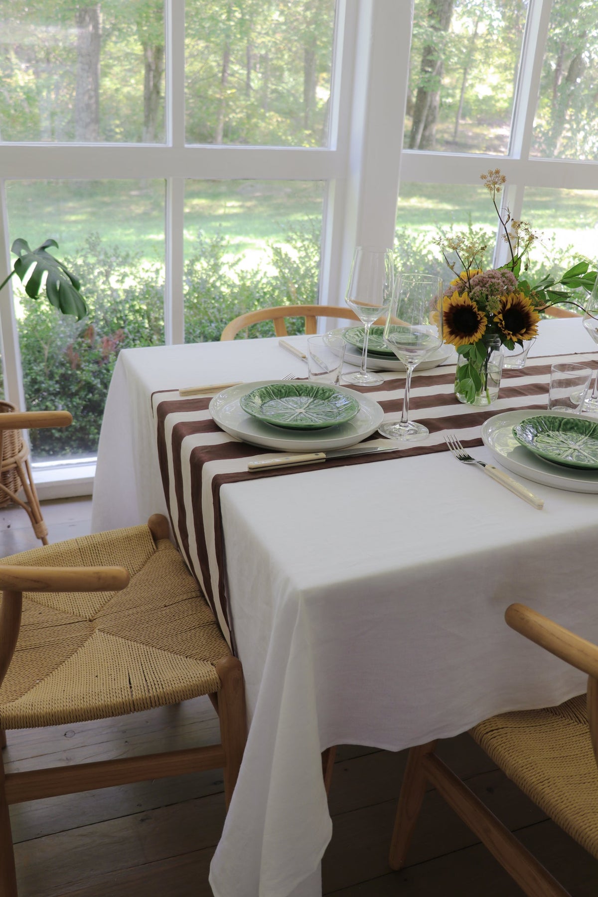 Cocoa and white striped table runner centered along a set dining table.