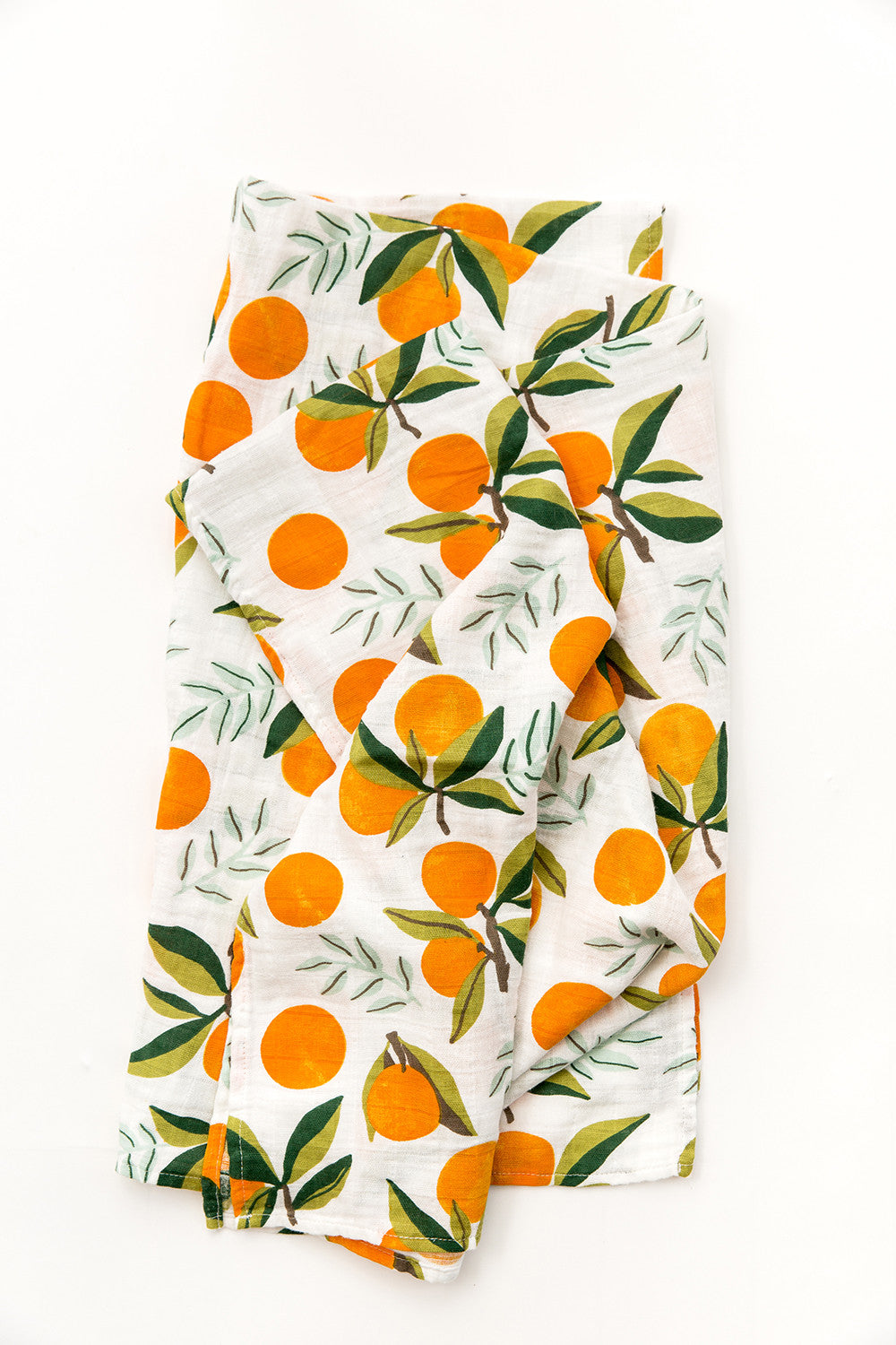 Swaddle blanket with orange fruit and green leaves on white, folded.