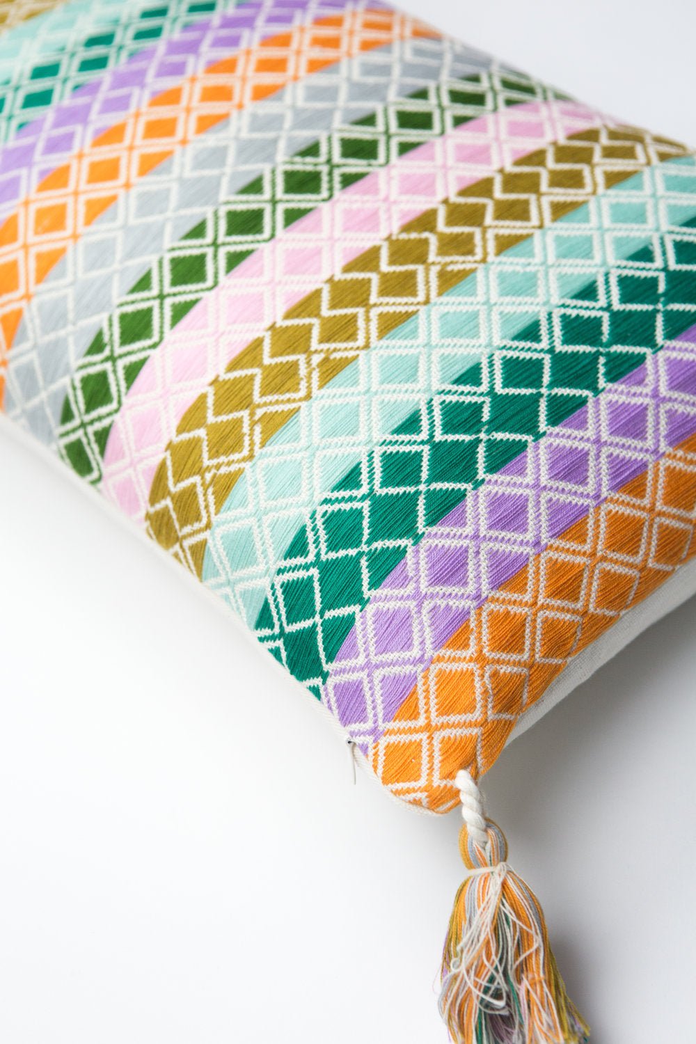 Geometric striped pillow corner with multicolor tassel tie detail