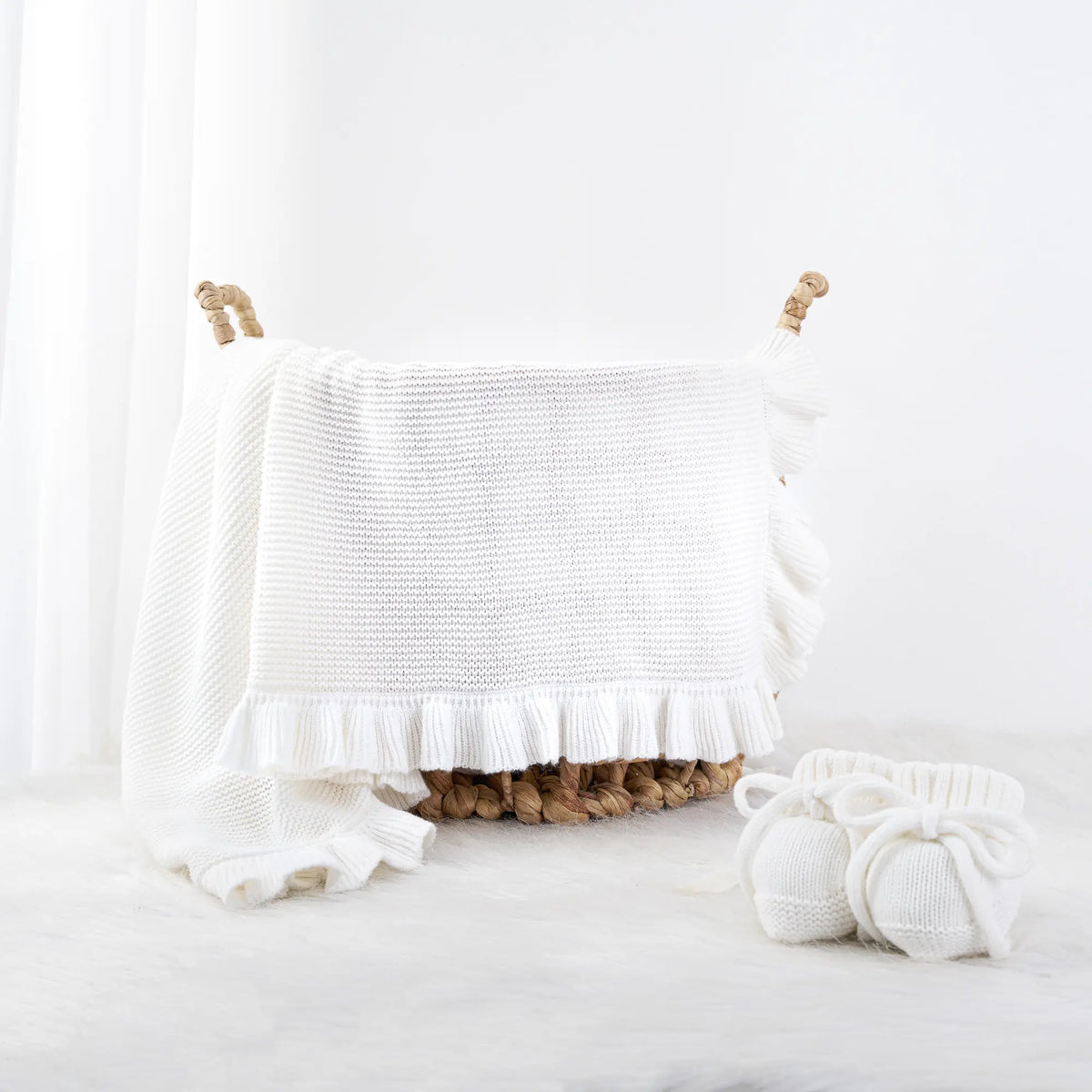 White knit baby blanket with ruffled border and hanging edge detail