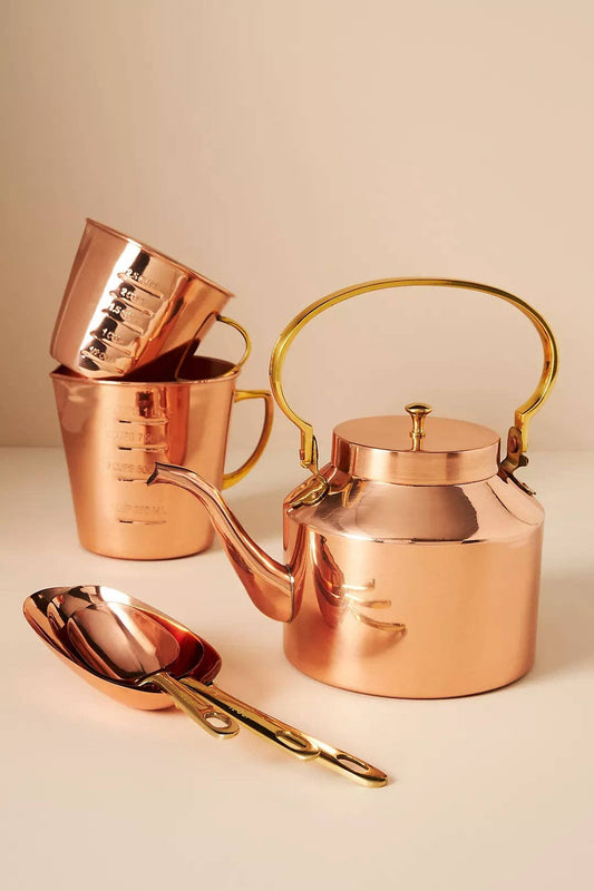 Copper measuring cups with long handles and oval bowls