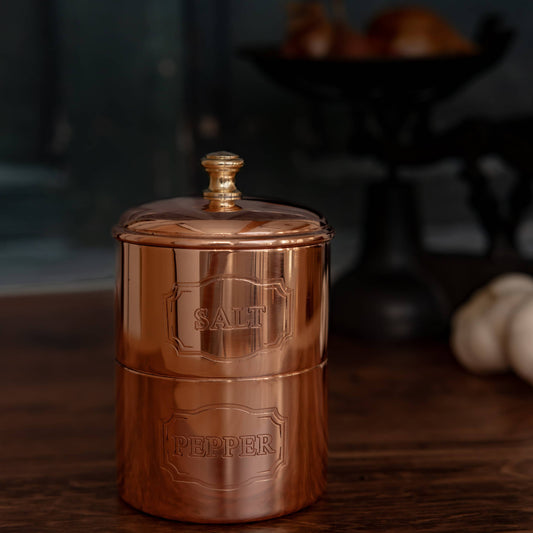 Copper salt and pepper cellar with domed lid, engraved 'SALT' and 'PEPPER'.