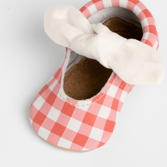 Red-and-white gingham baby slip-on shoe with white knotted bow strap detail