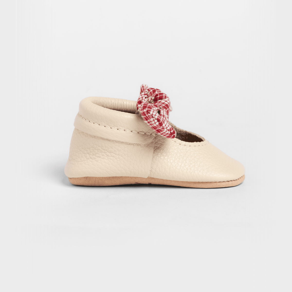 Prairie Girl baby shoe with knotted red plaid bow on cream leather upper