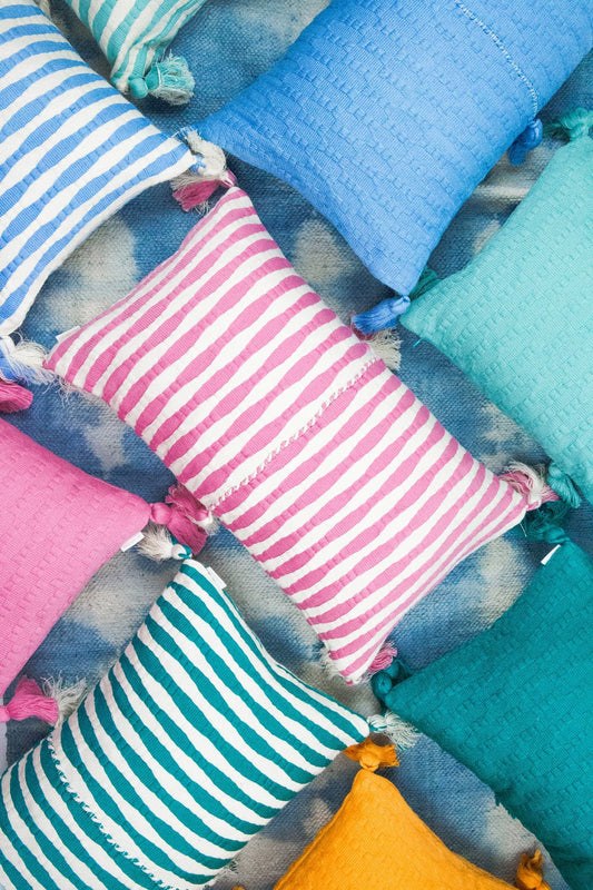 Set of stitched accent pillows in blue tones with tassels at the corners