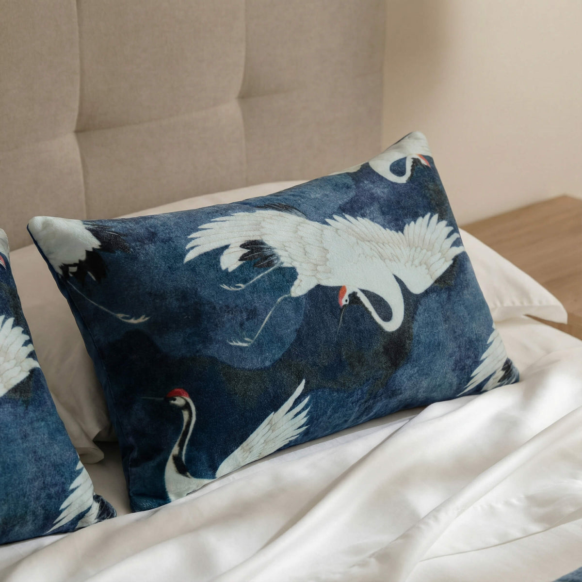 Blue small lumbar pillow with white cranes and subtle red beak embroidery pattern.