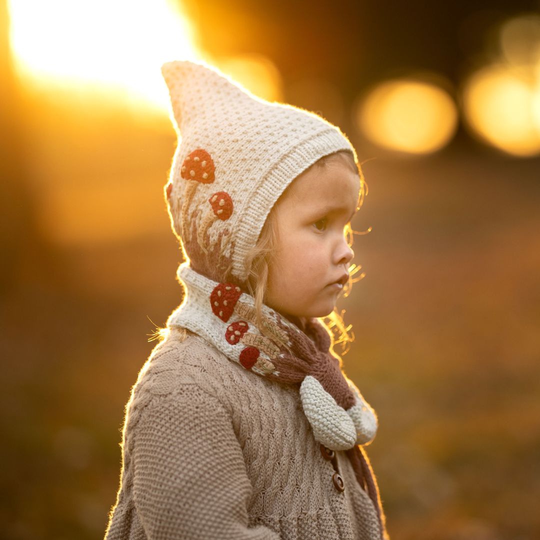Cream knit mushroom neck scarf with red capped mushrooms and ribbed trim