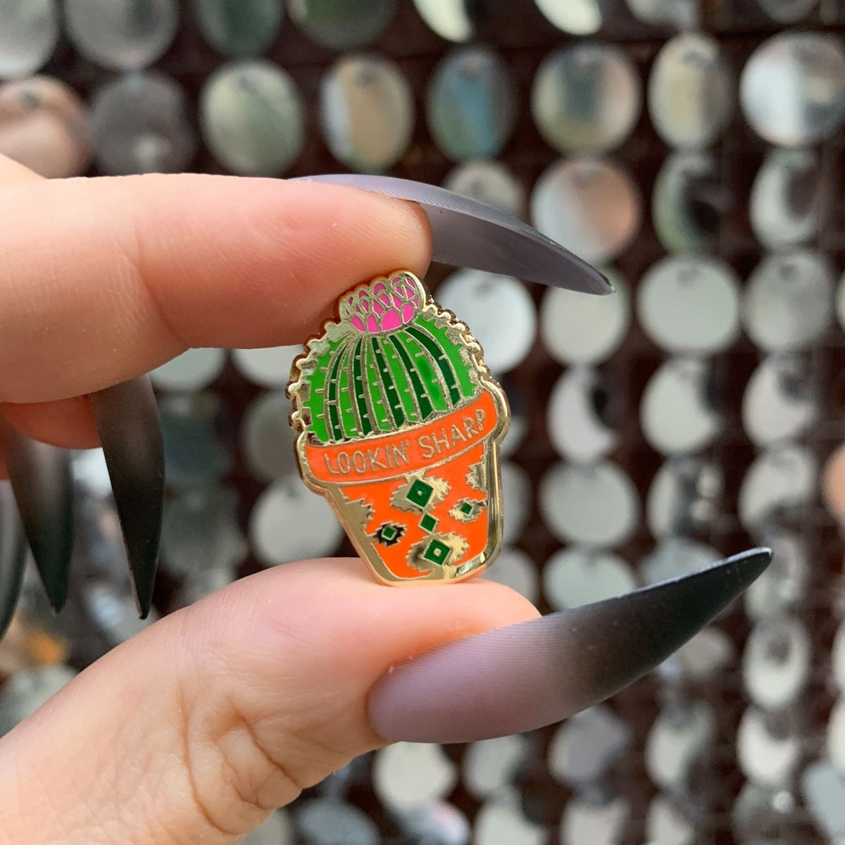 Cactus enamel pin with green striped top and orange bottom, gold-tone outline