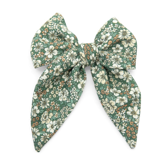 Green floral fabric hair bow with big tied loops and long trailing tails