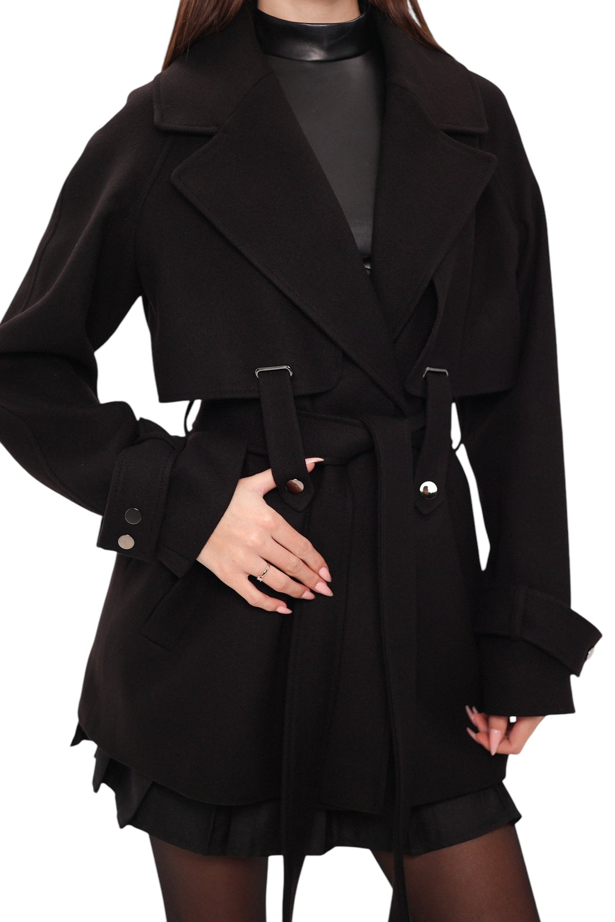 Front detail of the black coat's wide lapels, belt, metal buttons, and cuff tabs.