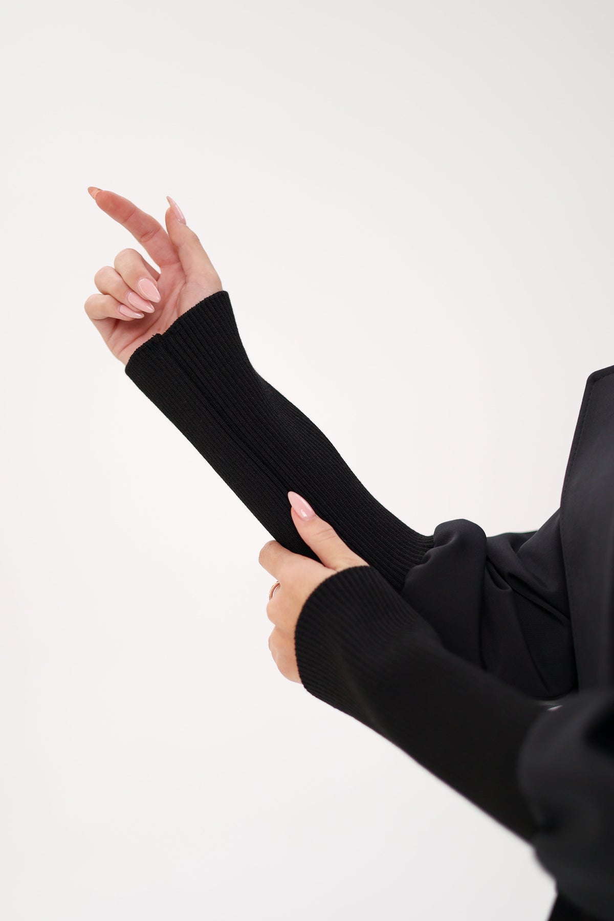 Black trench coat detail showing a long ribbed knit cuff