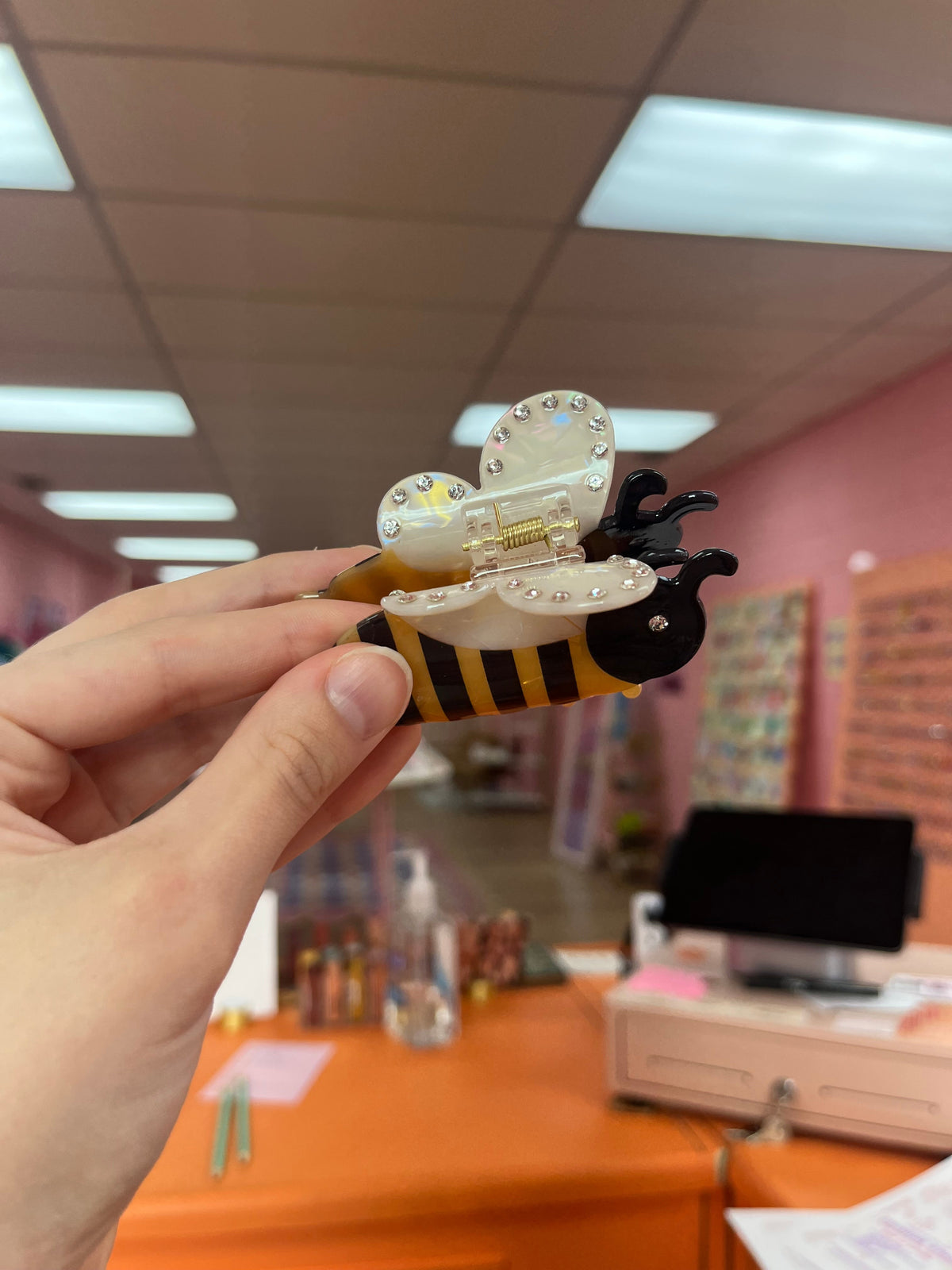 Bee hair claw with black and yellow striped body, clear glitter wing details
