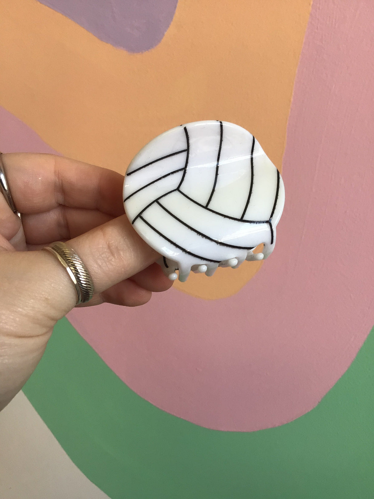 Volleyball-shaped hair claw clip with black stripe lines on white