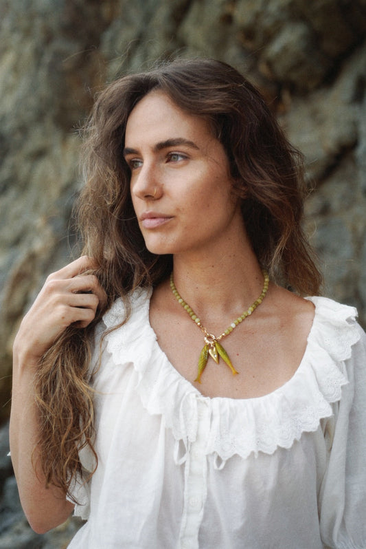 Olive bead fish pendant necklace on model with twin fish charms
