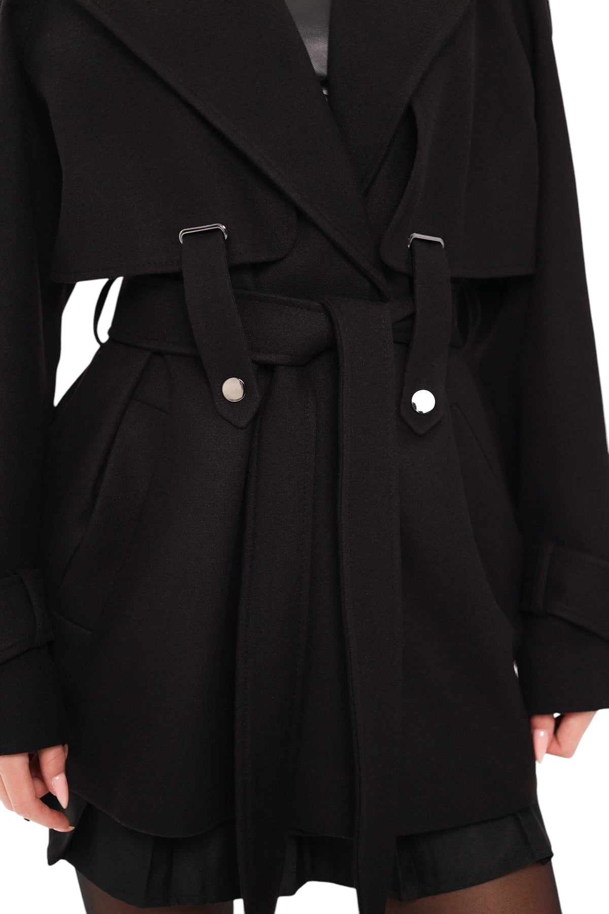 Close-up of black coat belt, buckle tabs, lapels, and cuff buttons