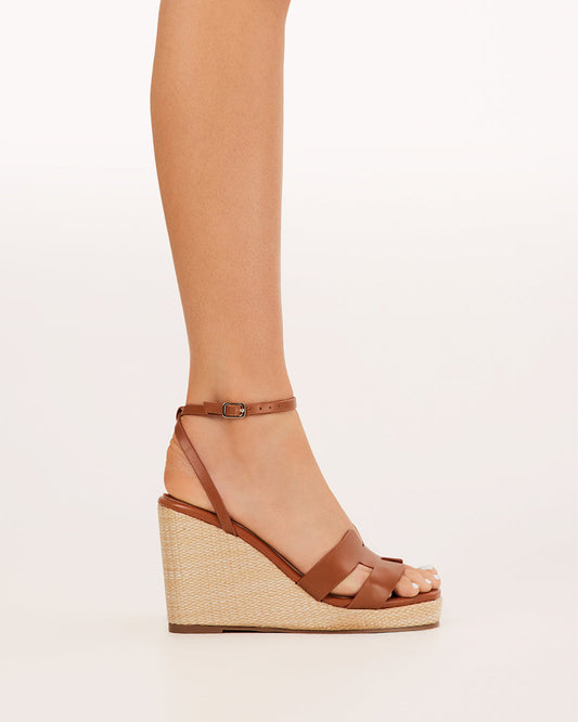 Tan wedge sandals with ankle buckle strap and open toe, woven textured midsole