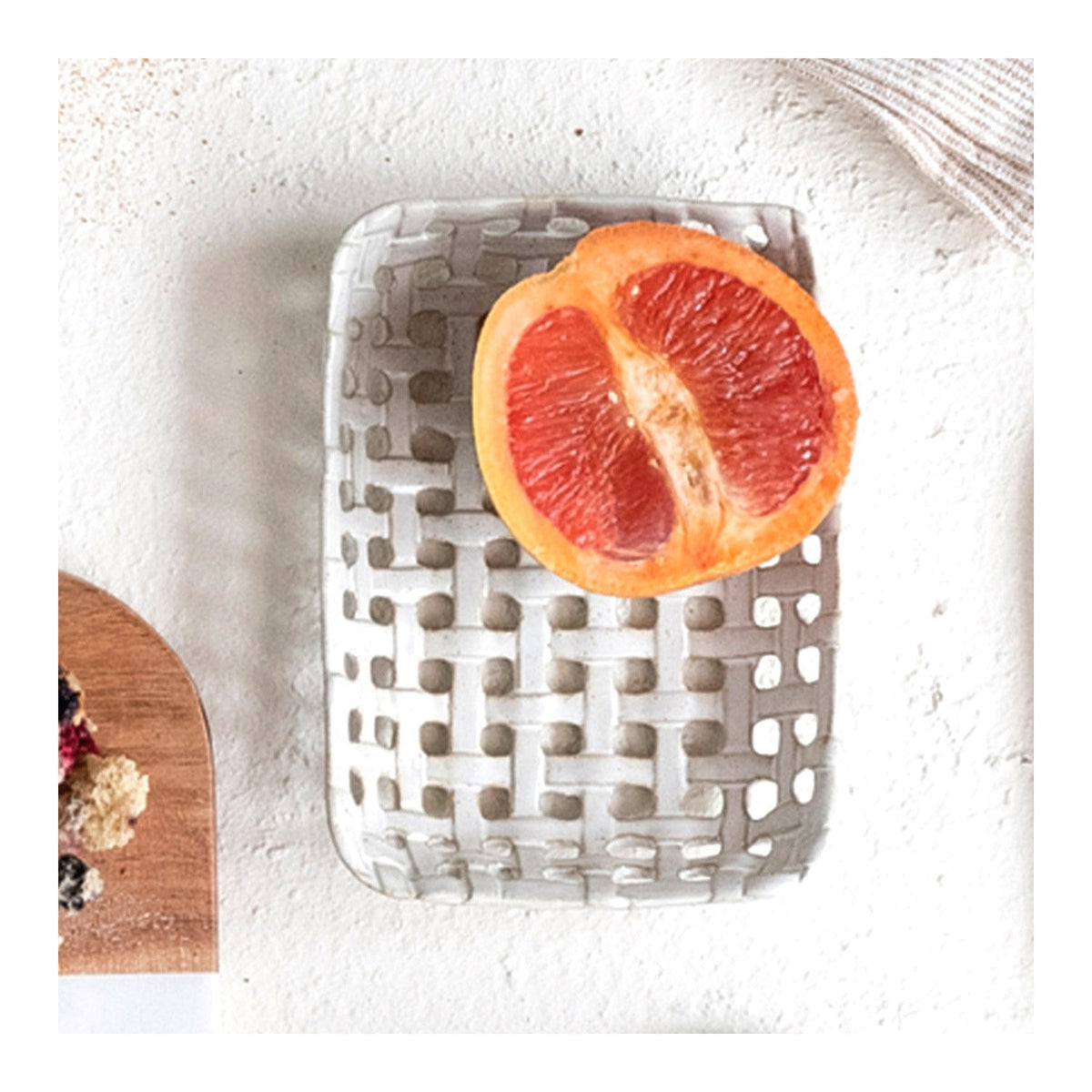 Cream ceramic lattice basket dish holding a grapefruit slice