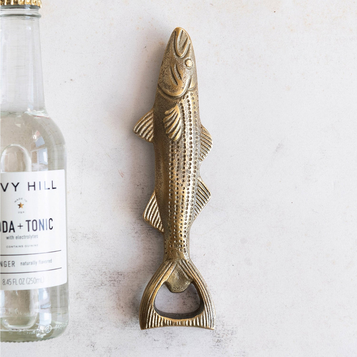 Antique gold fish bottle opener with open-jaw detail and bottle-cap ring