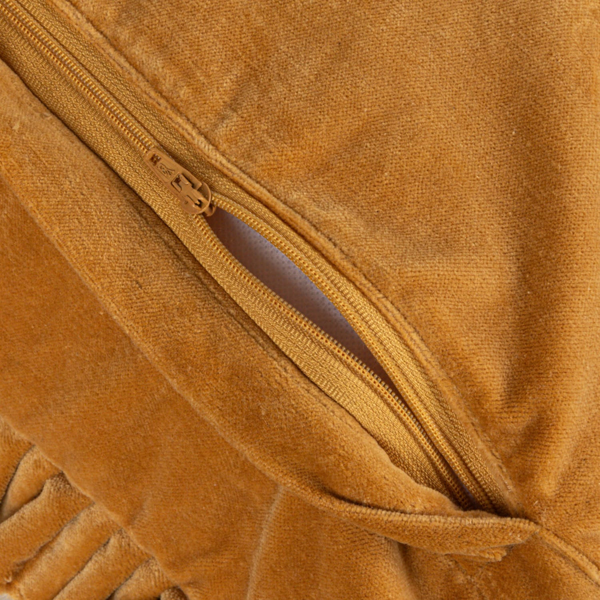 Mustard cotton velvet pillow close-up of zipper seam and ruffled trim