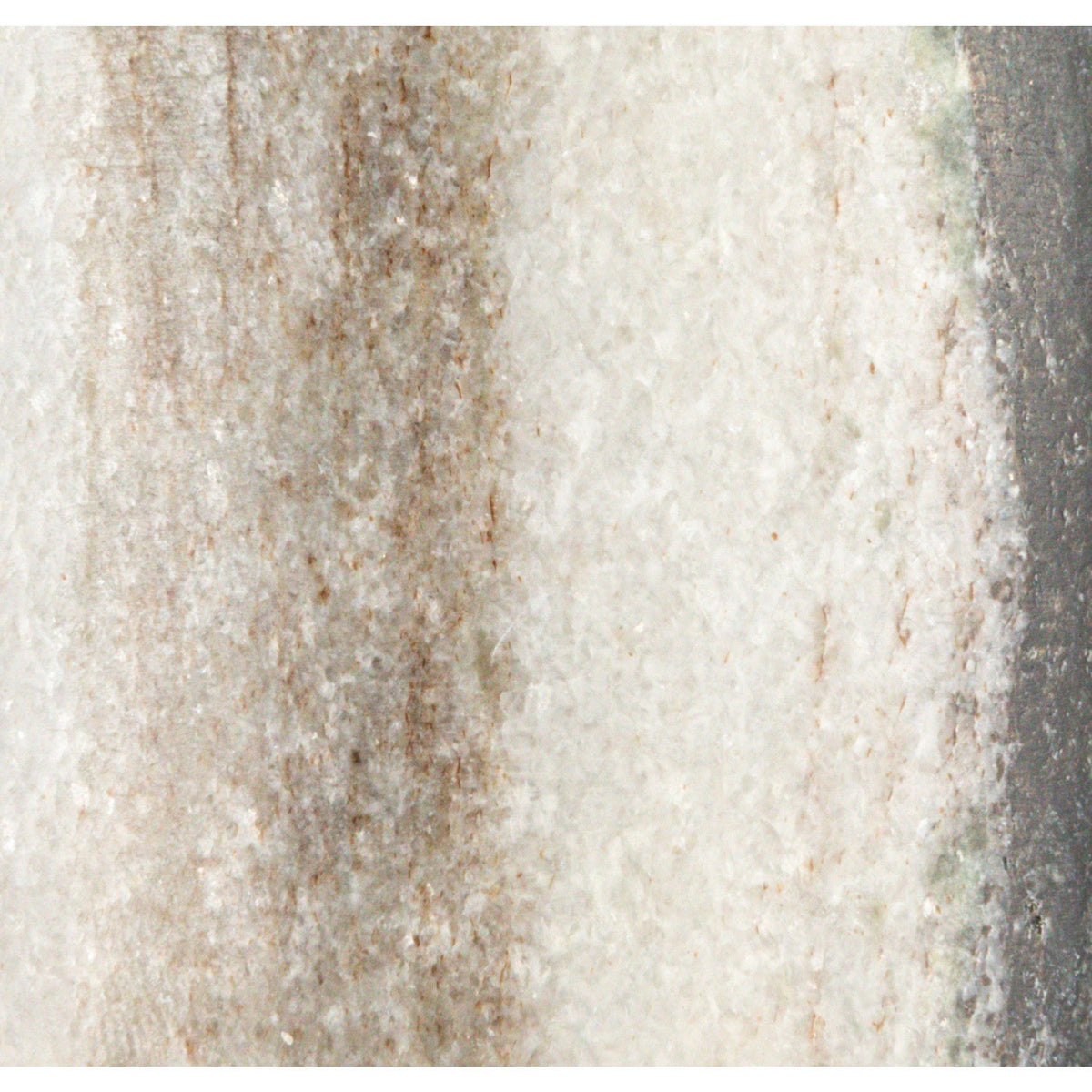 Close-up marble salt cellar texture, cream with tan and dark speckling