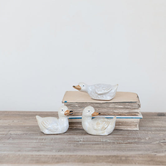 Set of three ceramic duckling figurines, pale white glaze with orange beaks and feet