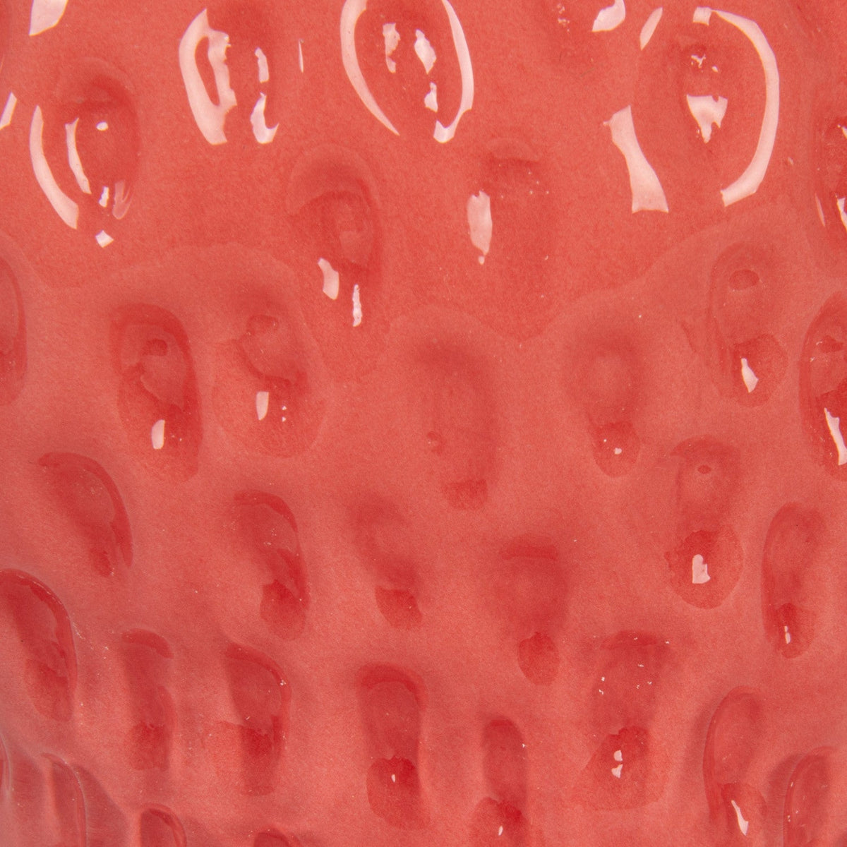 Close-up of pink opaque glass vase texture with raised strawberry-like bumps