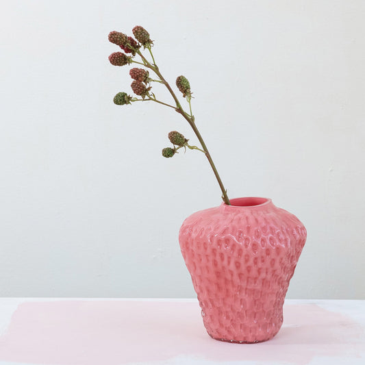 Pink opaque strawberry-shaped glass vase with textured pattern and red rim opening