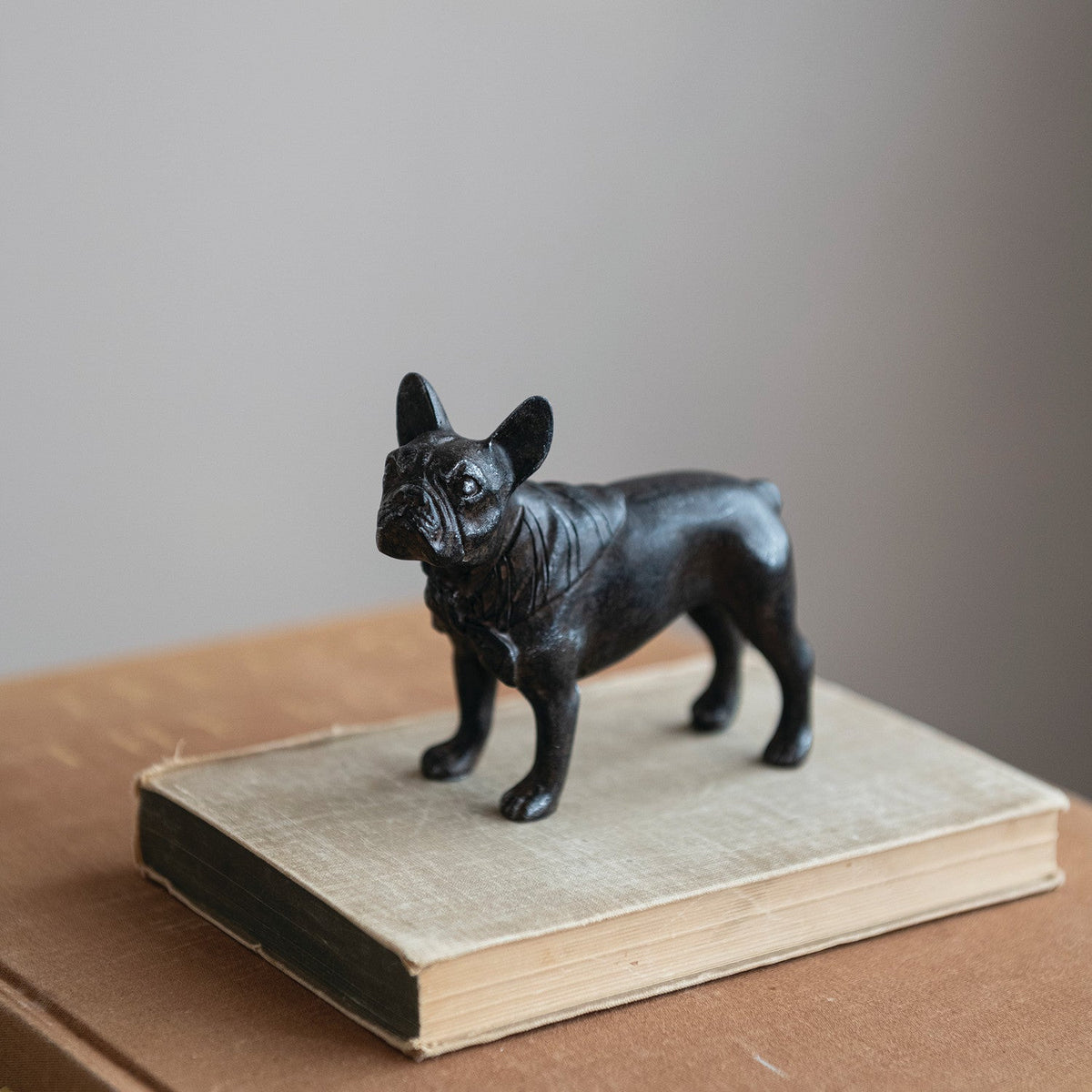 Black French bulldog resin figurine, front-left angle, glossy textured surface.