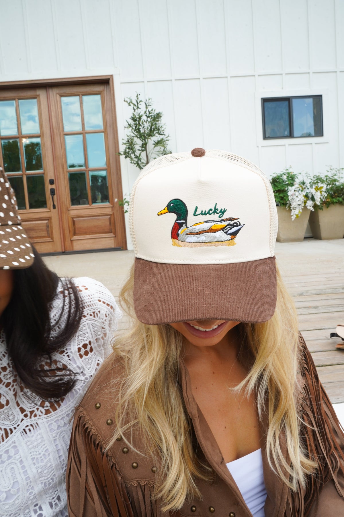 Cream front panel trucker hat with brown corduroy brim and duck “Lucky” embroidery.