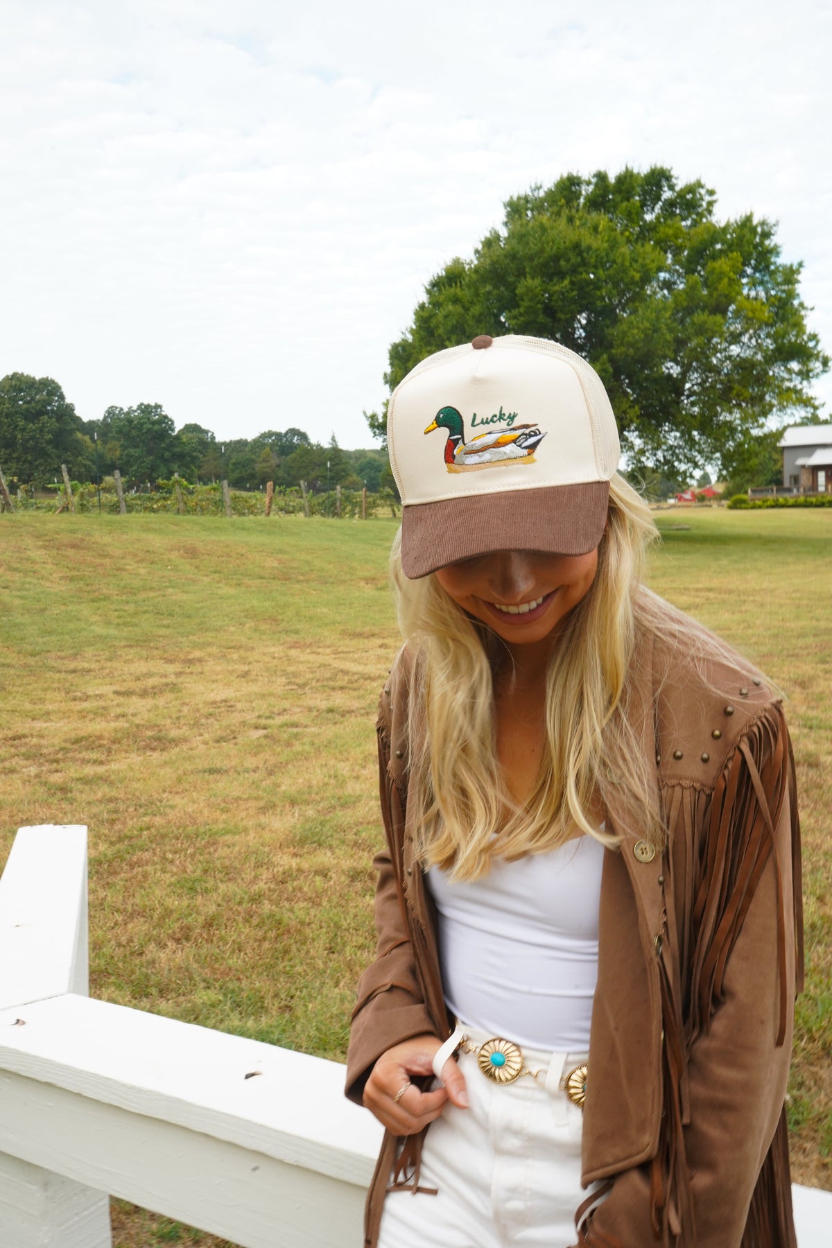 Cream front and brown corduroy brim trucker hat with duck “Lucky” graphic.