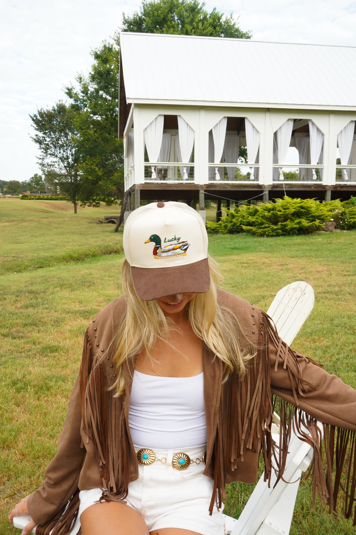 Cream front trucker hat with brown corduroy brim and embroidered duck “Lucky” patch.