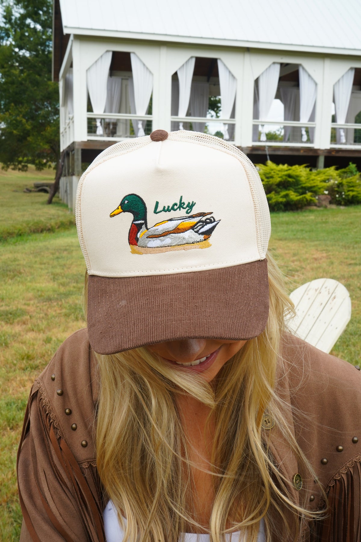 Two-tone trucker hat with cream mesh back, brown corduroy brim, and duck “Lucky” logo.