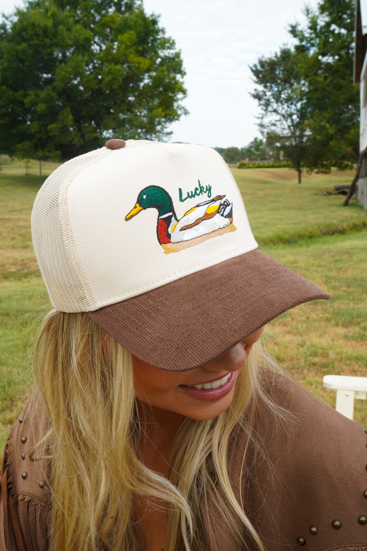 Front close-up of brown corduroy trucker hat with duck logo embroidery.