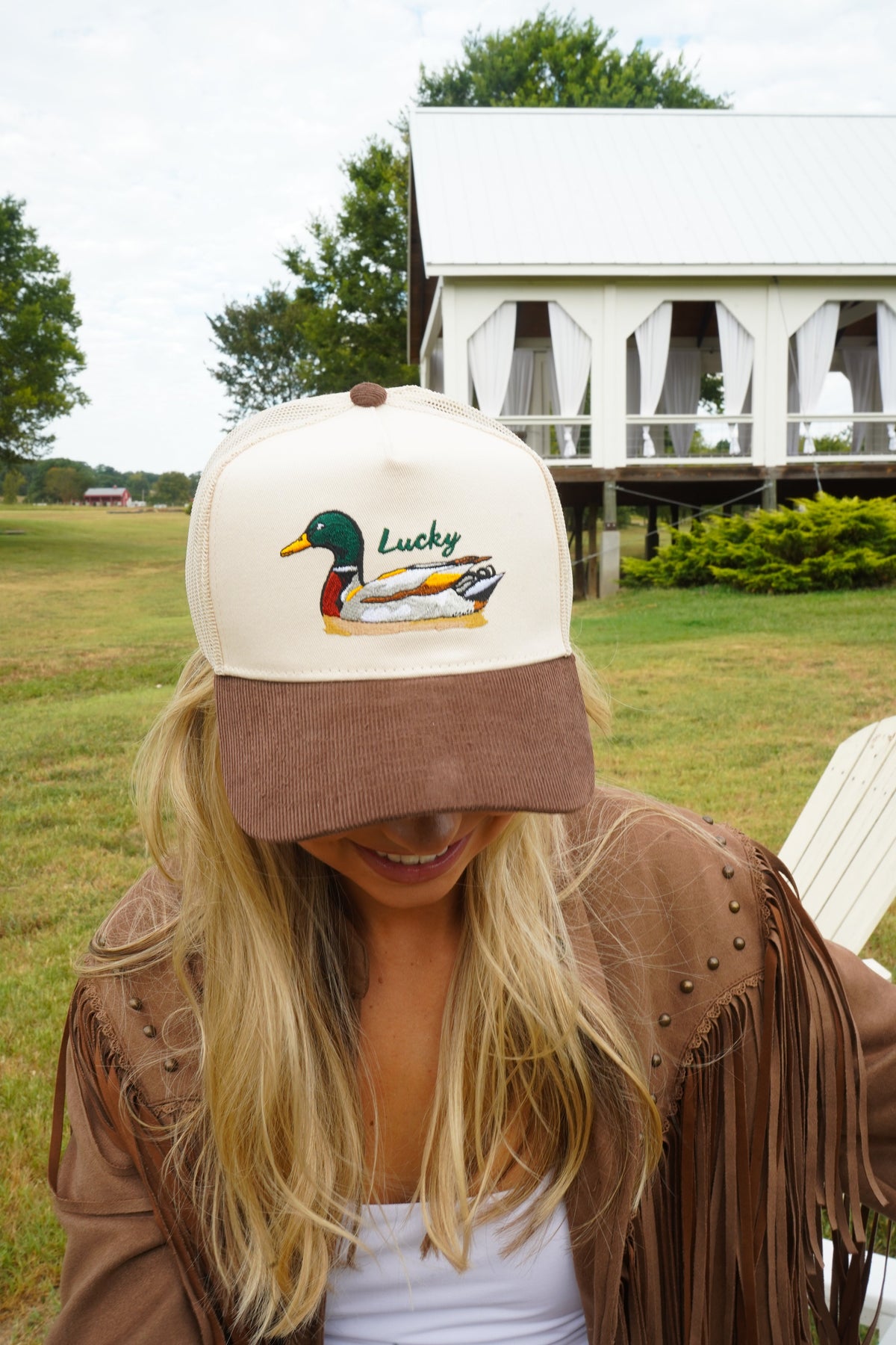 Side view of brown corduroy trucker hat with white mesh back and duck logo.