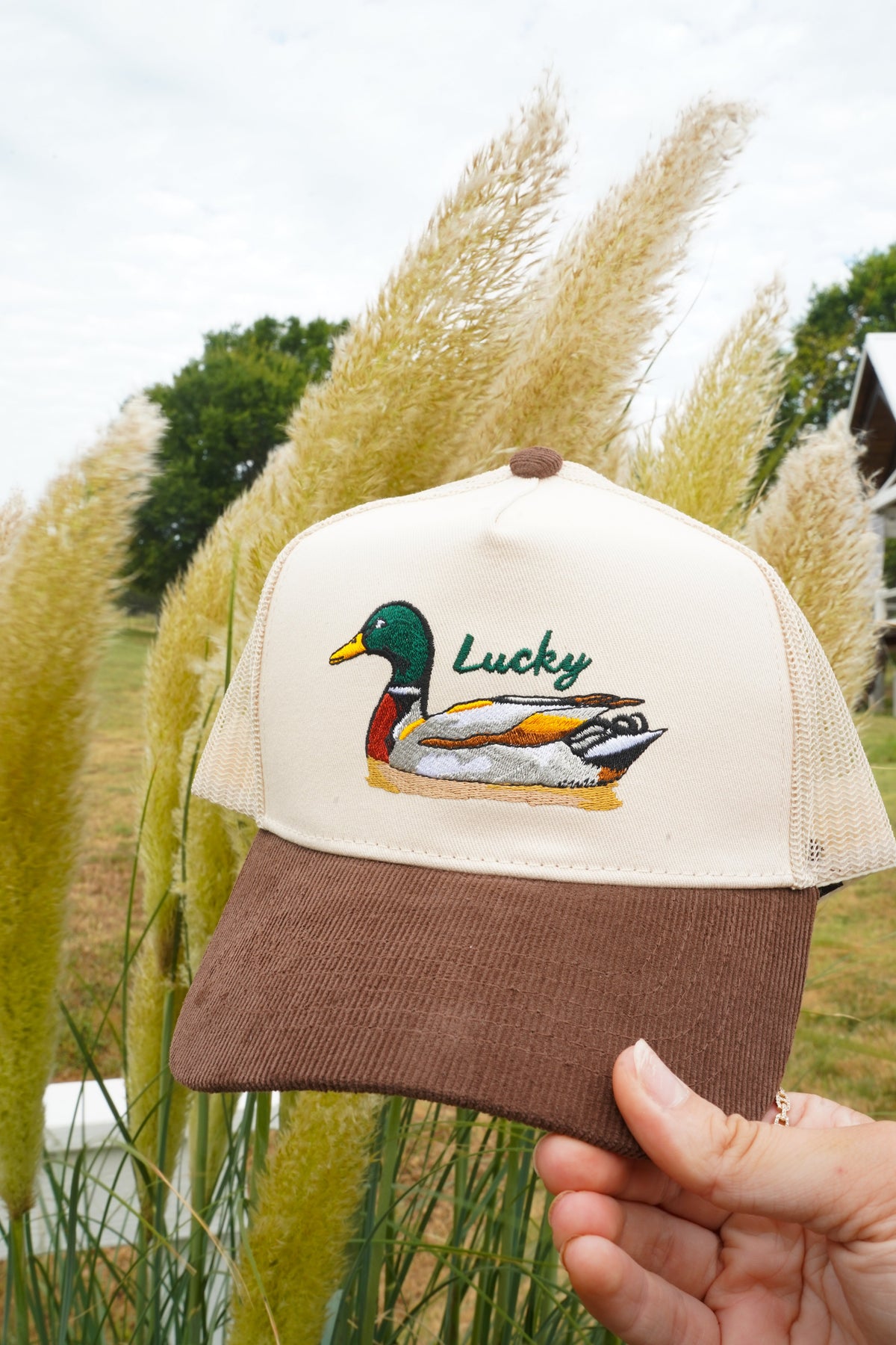 Brown corduroy trucker hat with cream mesh front panel and Lucky duck patch