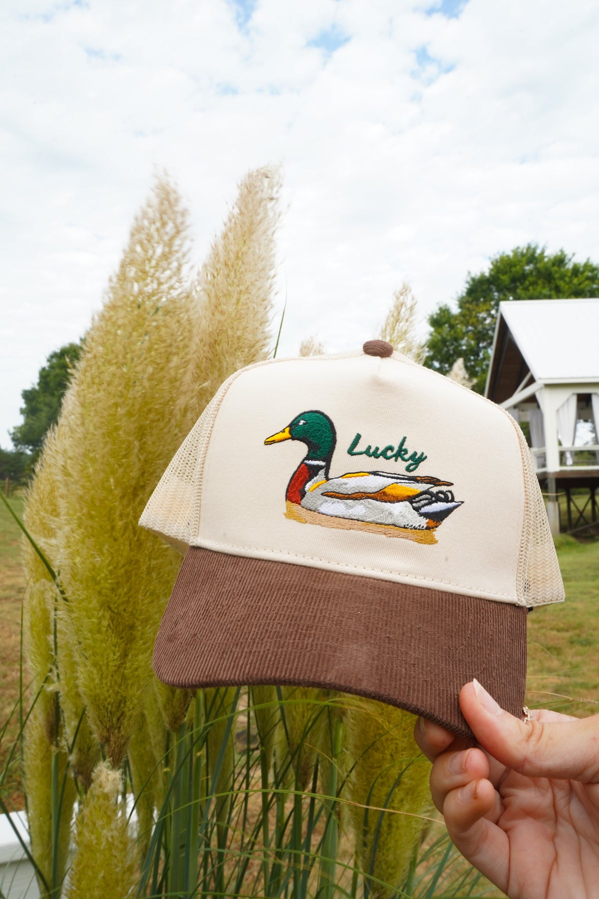 Brown corduroy trucker hat with cream mesh front panel and Lucky duck embroidery