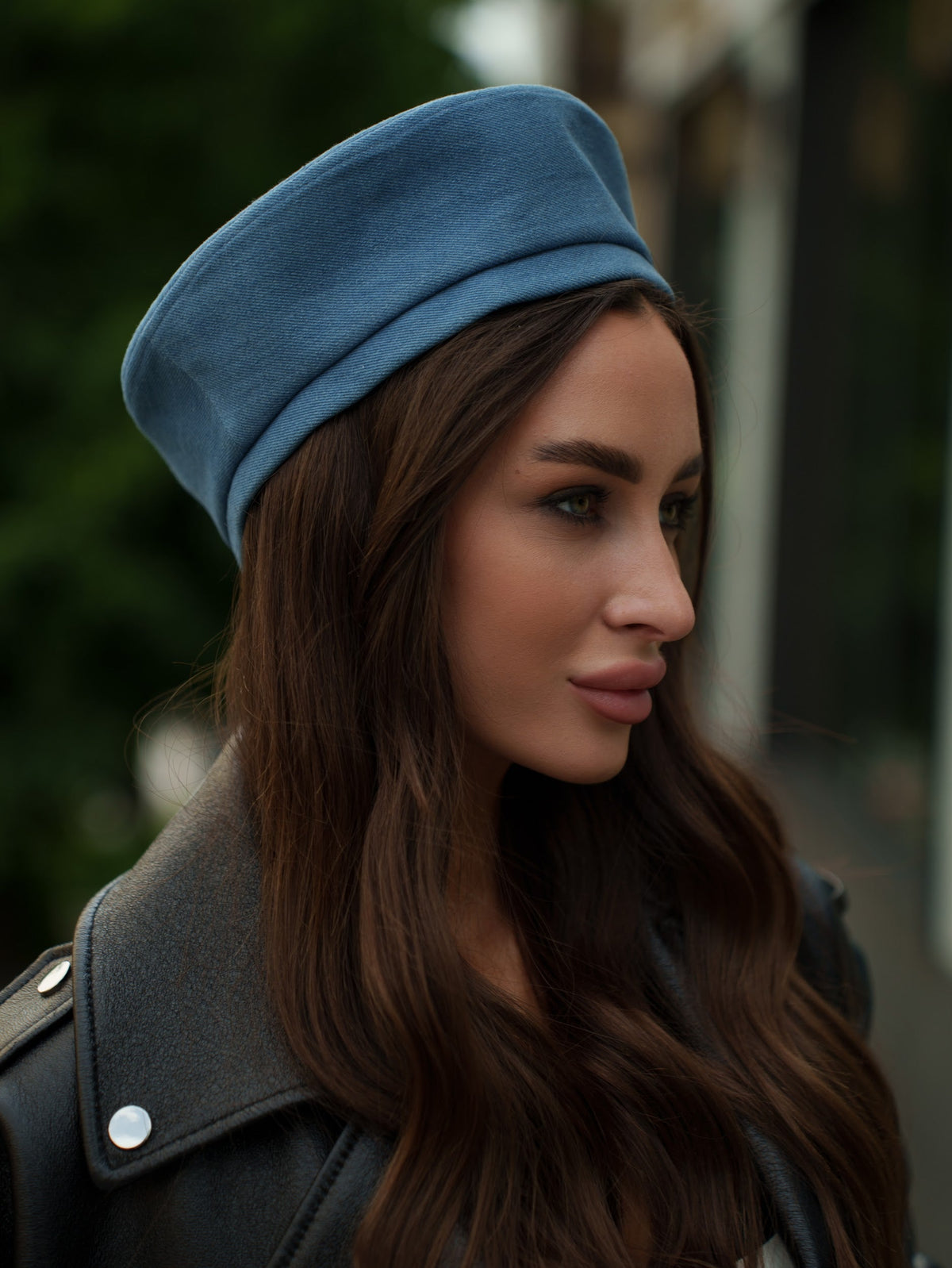 Blue Paris beret worn at an angle, showing its soft rounded crown and folded band