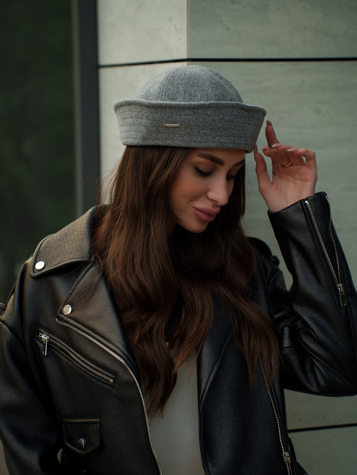 Light grey sailor hat with a small gold-tone pin on the front band, shown worn