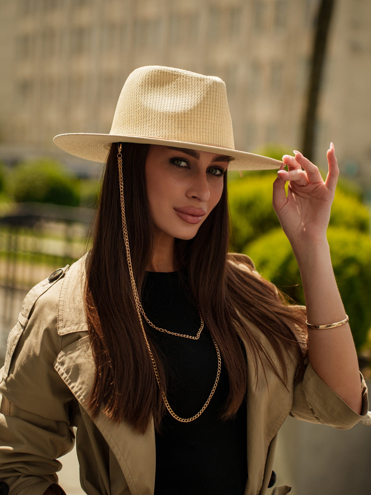Light beige paper straw hat with a wide brim and thin double chain trim, worn on a model