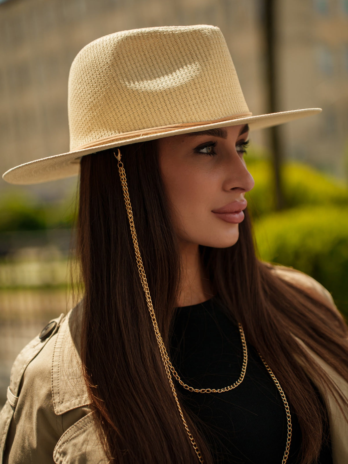 Tribli paper straw hat showing its woven texture, wide brim, and long gold chain detail
