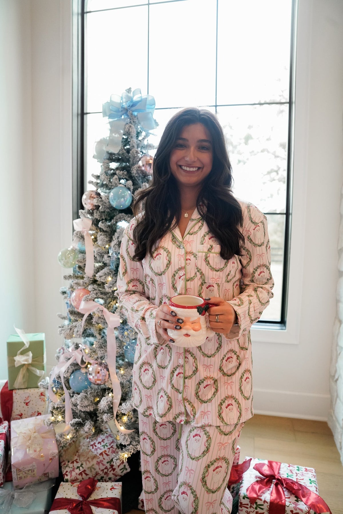 Santa and wreath print pajama set, long-sleeve button top and matching pants in pink and white.