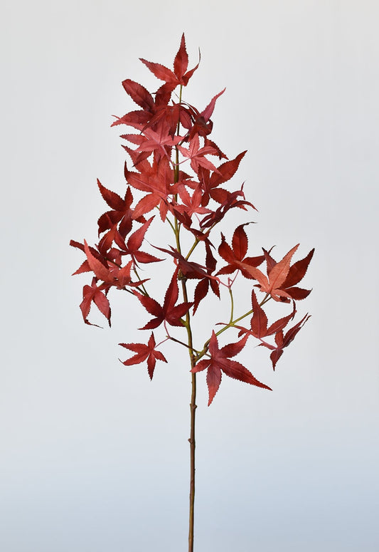 Faux Japanese maple leaf stem with red maple leaves on a tall green-brown stem
