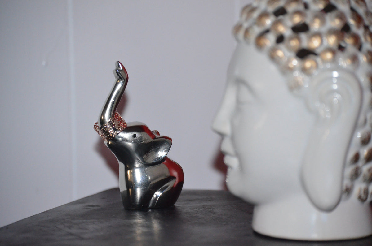Silver elephant ring holder with red accents on the raised crown