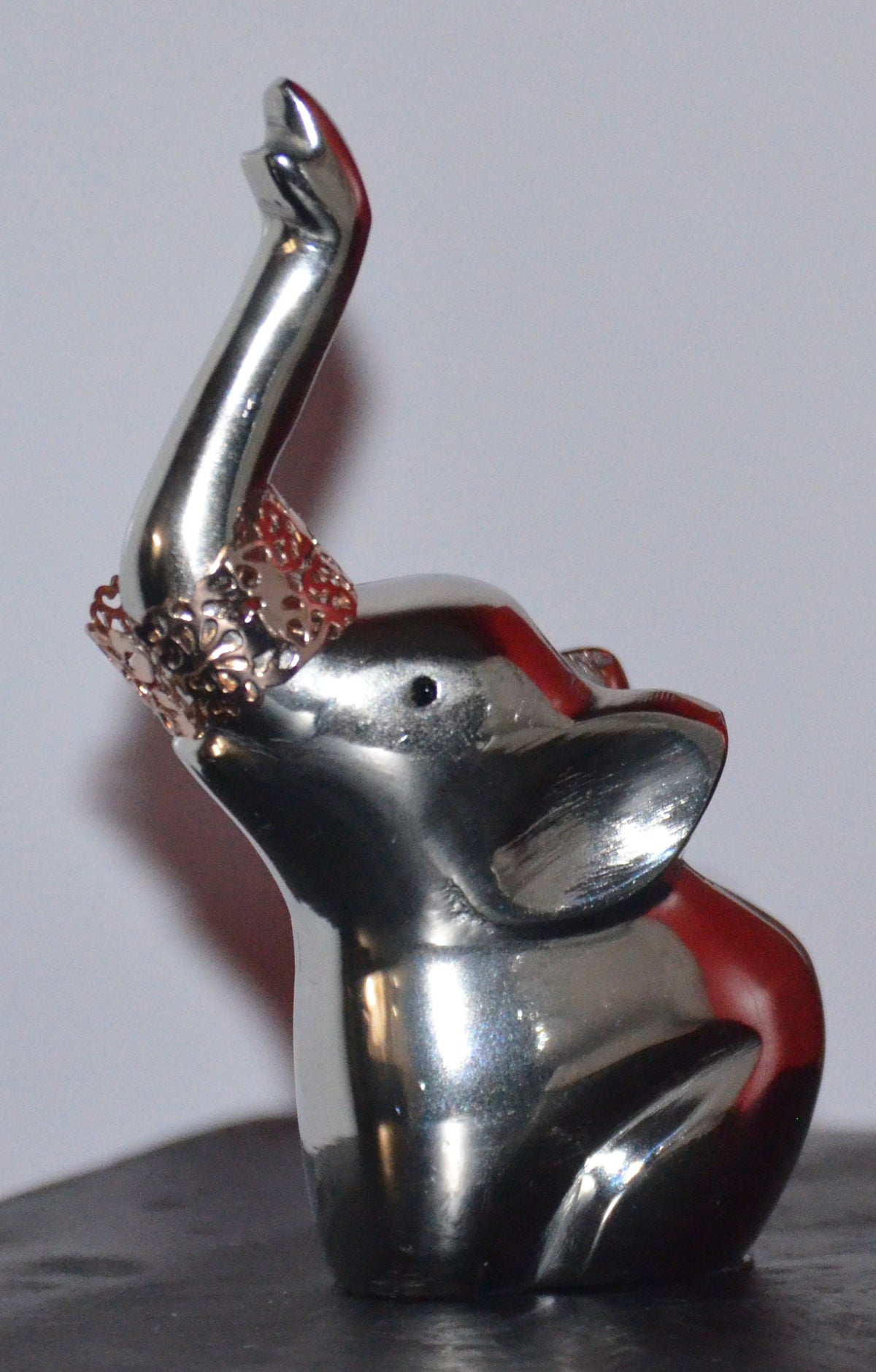 Silver elephant ring holder with red details on the raised top